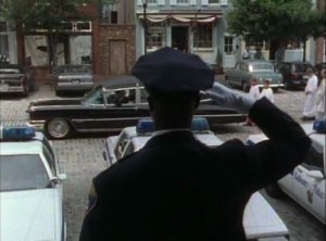 Image: Still shot of scene from Homicide: Life on the Streets. Frank Pembleton (played by Andre Braugher) in dress uniform saluting a hearse as it passes by.