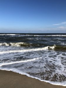 small, choppy waves crashing on the beach on a sunny day in November