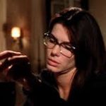 Sandra Bullock as Sally Owens in Practical Magic. Wearing glasses and contemplating a spell