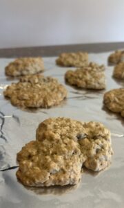Oatmeal, chocolate chip, and walnut cookies cooling on foil.